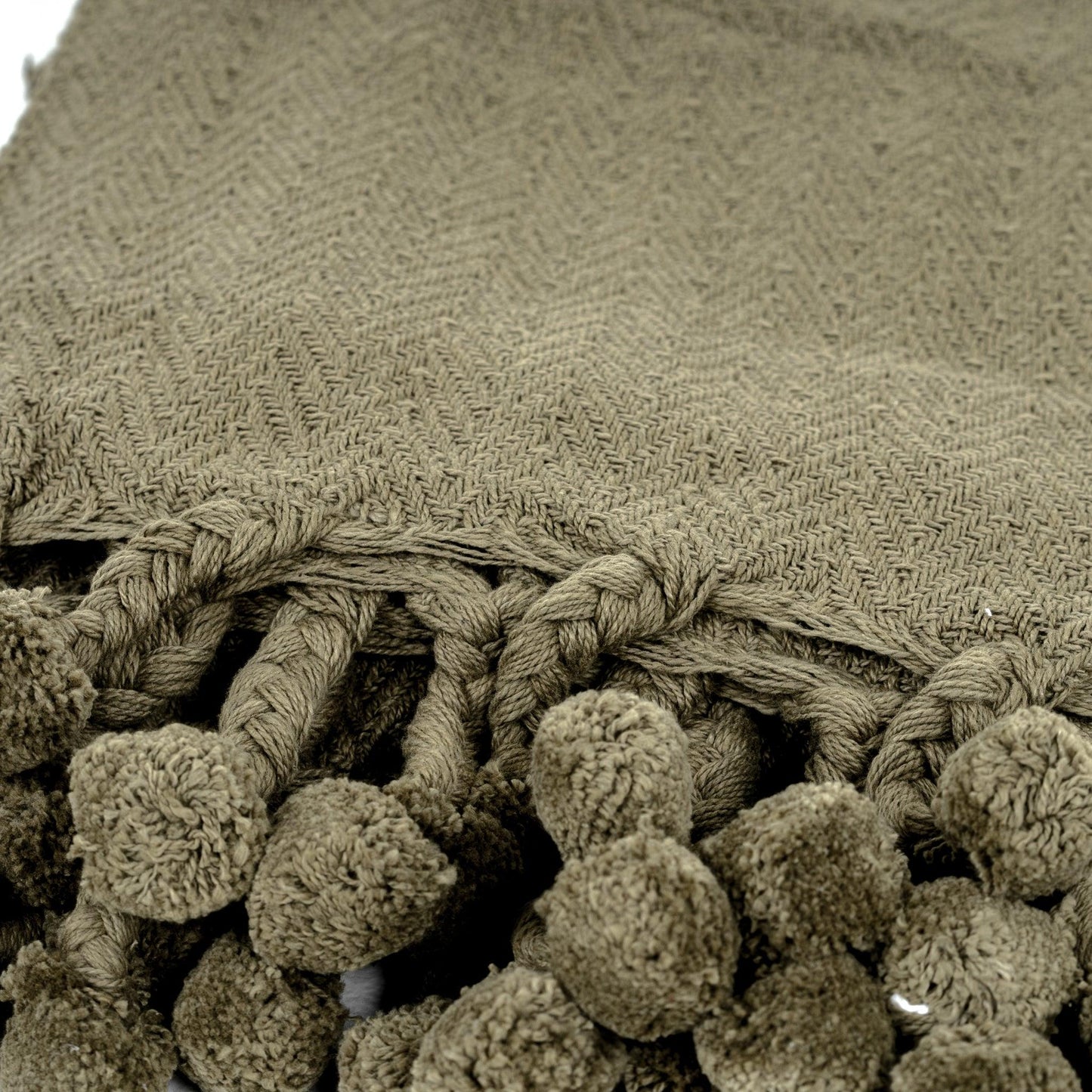 Coperta in cotone Vesla con nappe intrecciate a pompon in verde