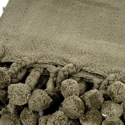 Coperta in cotone Vesla con nappe intrecciate a pompon in verde